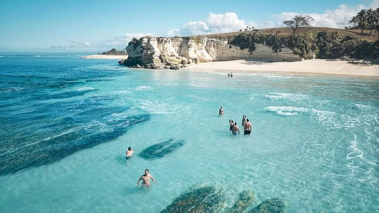 Turquoise bay with swimmers on the Sumba coast