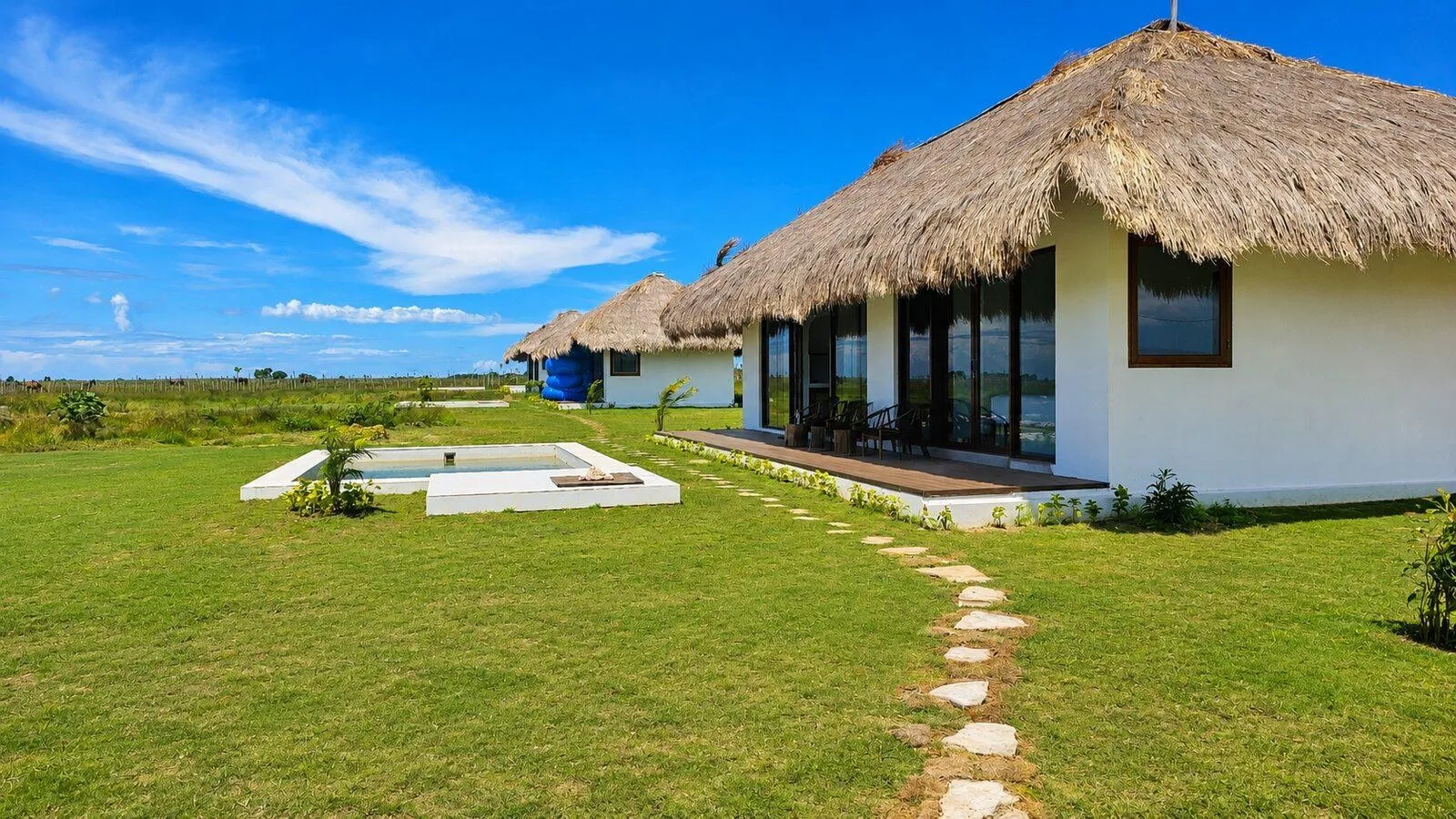 Thatched villas and a stone garden path at Eco Beach City